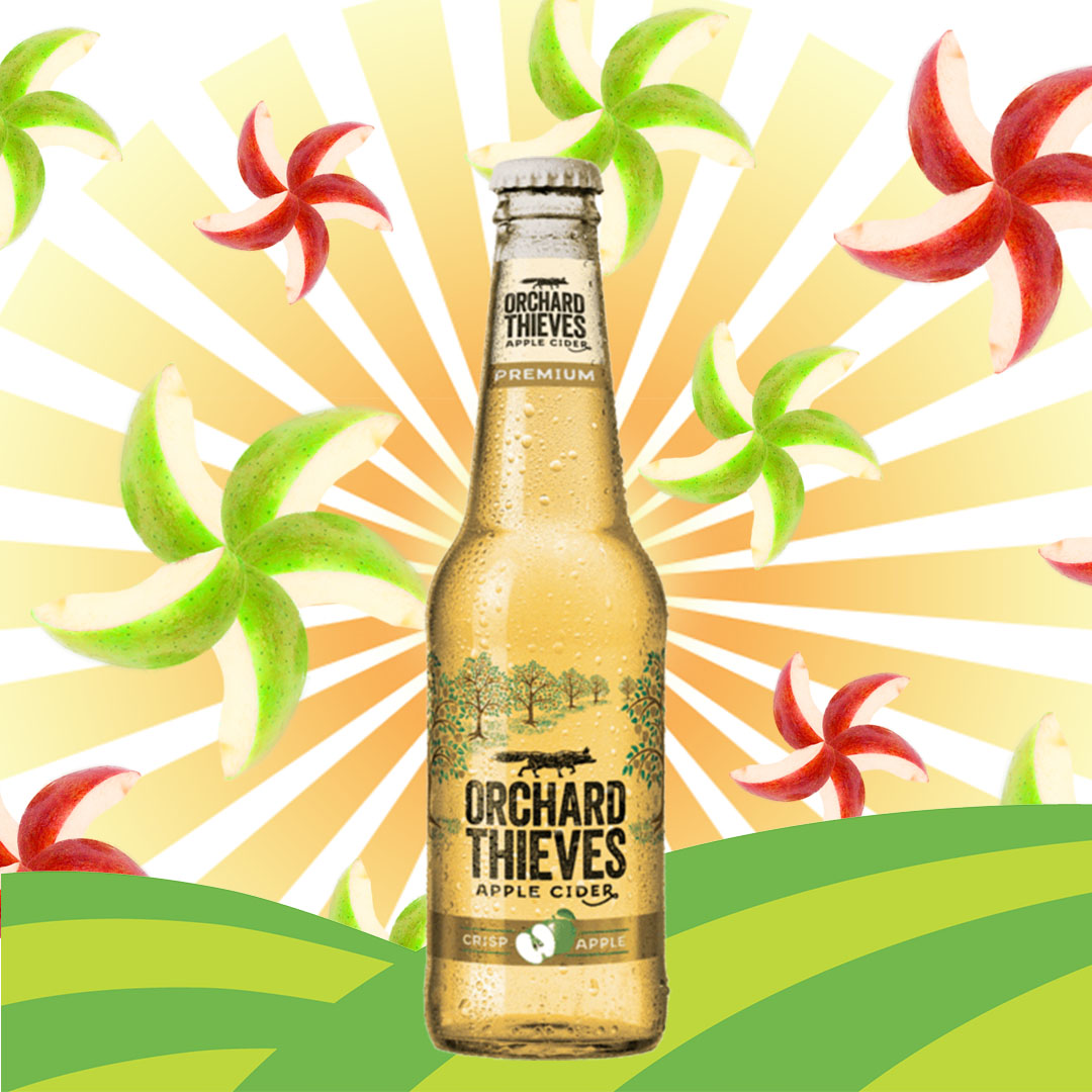 Bottle of cider with apple slices in the background.