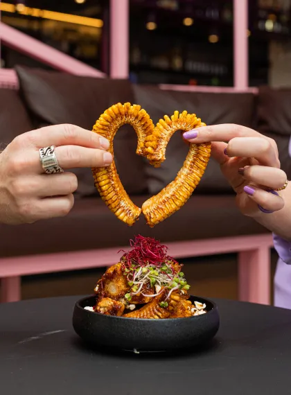 Twee handen die een a-maize-ing rib vasthouden zodat deze een hartje vormen.