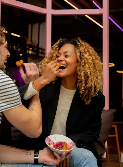 Een vrouw met krullen die een snack eet