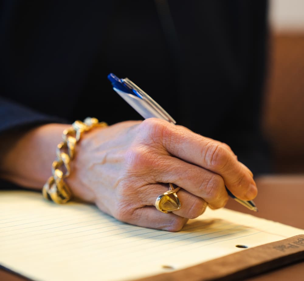Attorney at Mulliken Weiner Berg & Jolivet Logo writing notes