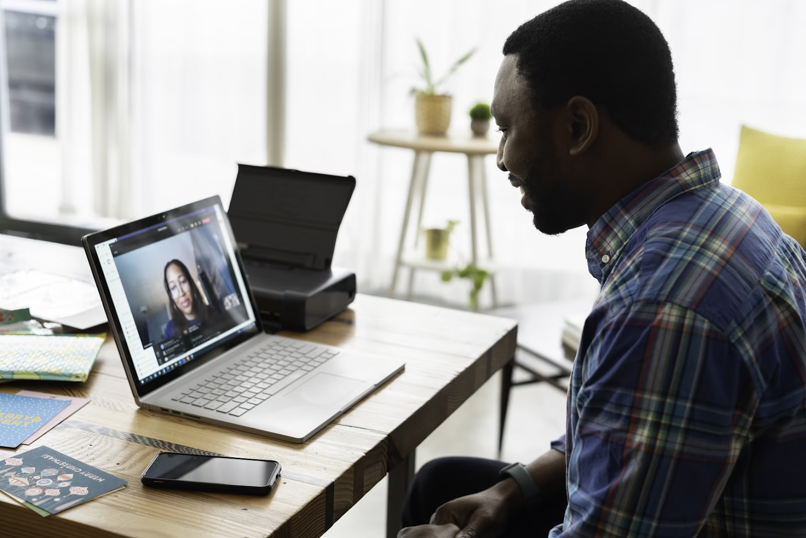 The man conducting an interview with a woman on a laptop.