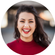 friendly woman wearing a long neck red blouse.