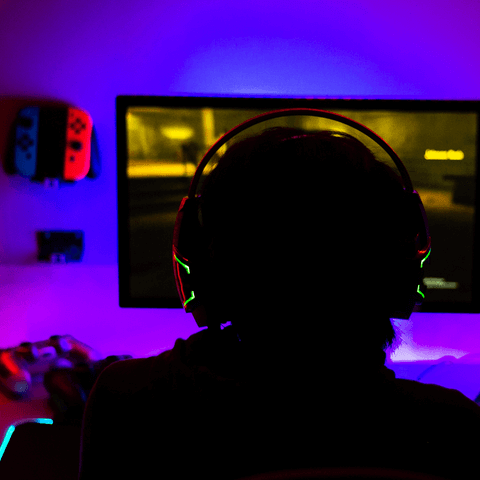 Esports teams member playing games at desk with purple background