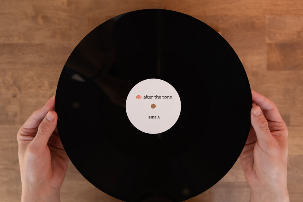 Hands holding custom vinyl of audio guestbook voicemails