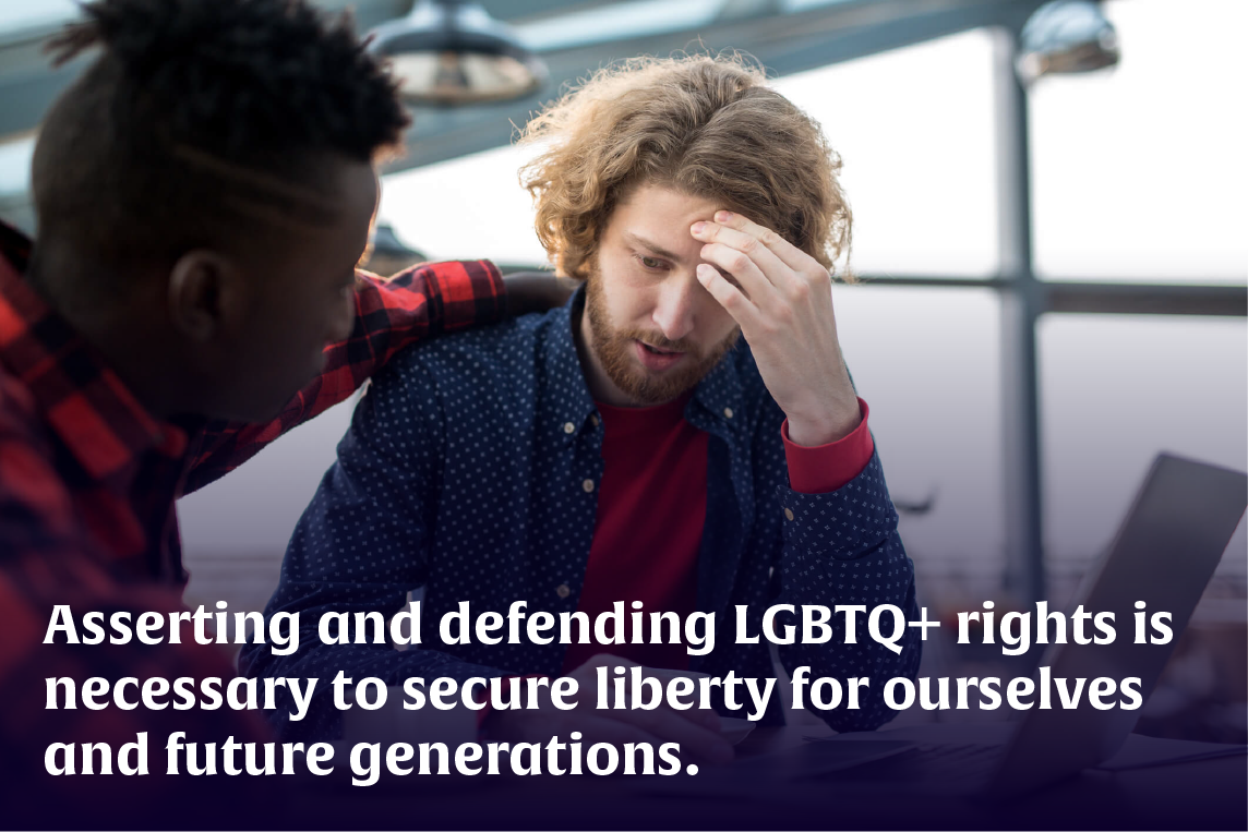 A bearded young man wearing flannel is comforted by another man at a coffee shop.