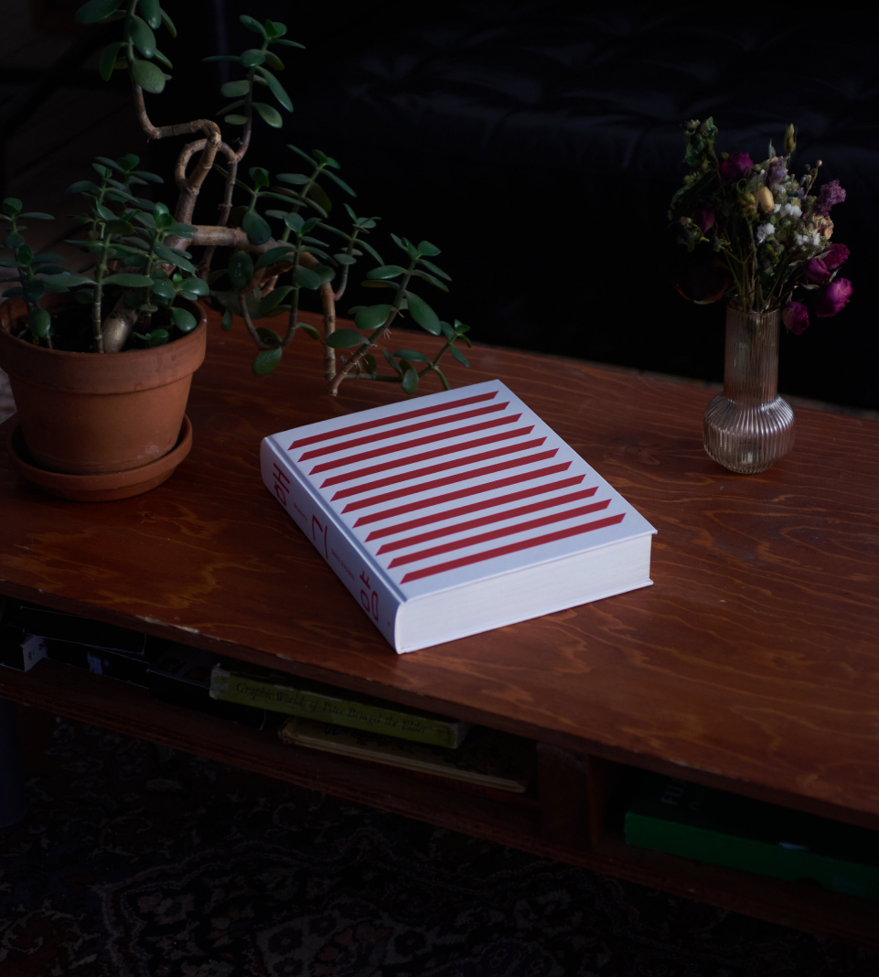 White book with red slanted lines on a brown coffee table