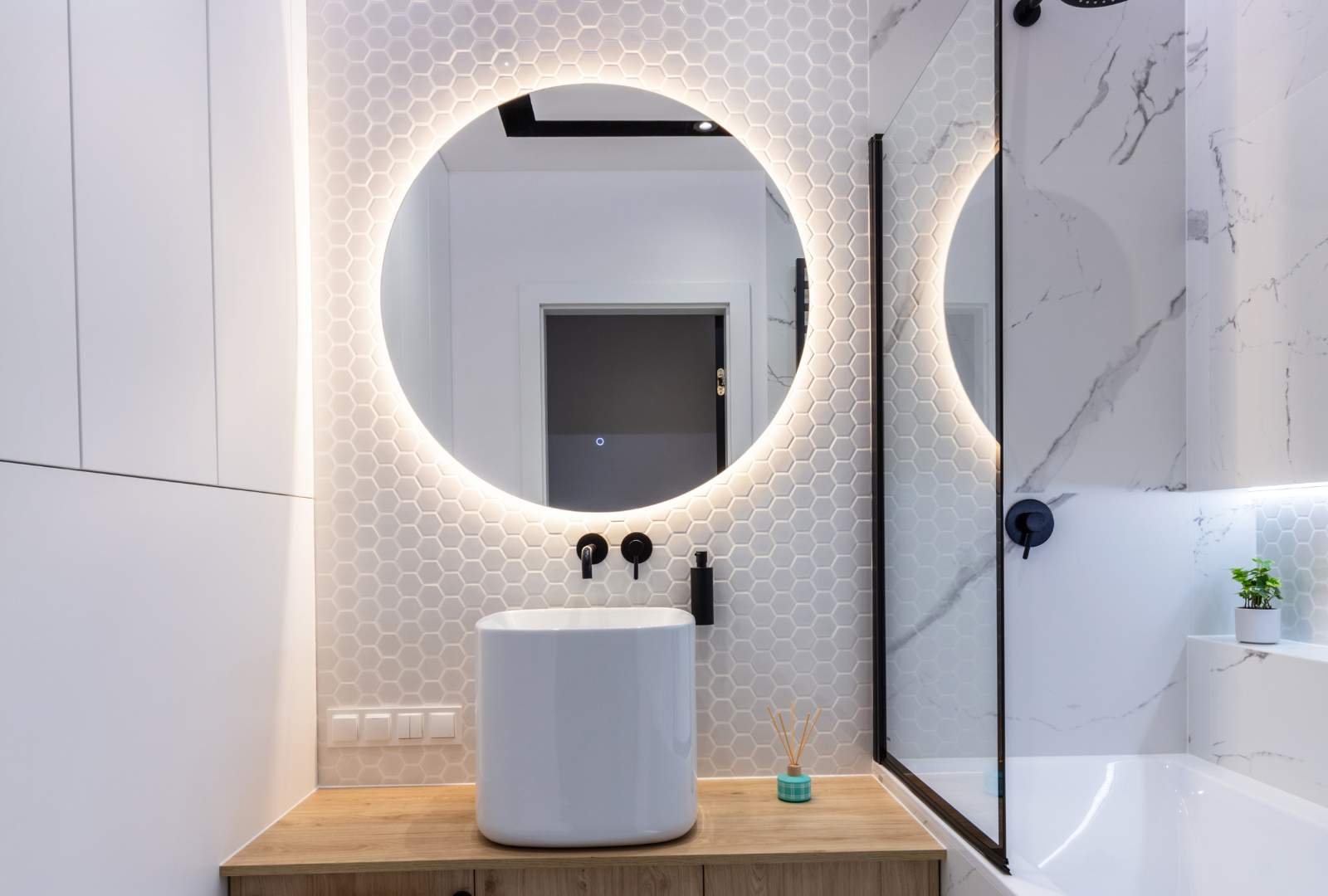 Modern sink and round mirror with led light in a bathroom