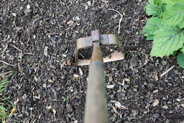 Copper swivel hoe cuts weed stems
