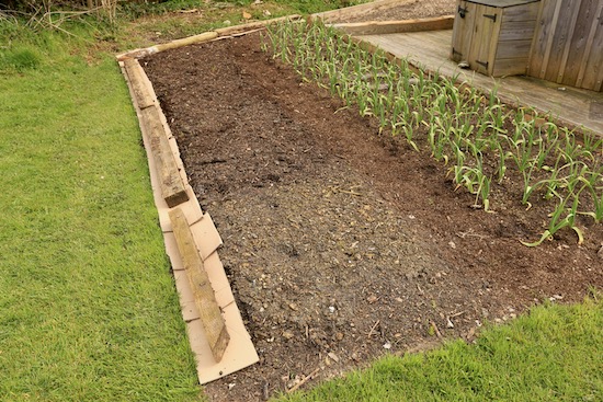 Using cardboard to clean a grassy edge
