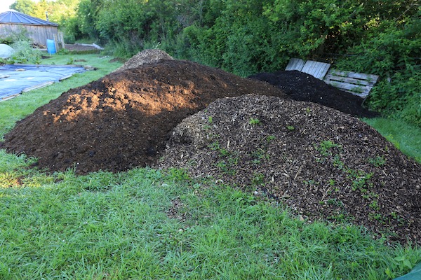 Heaps of woodchip, cow manure still hot and green waste compost