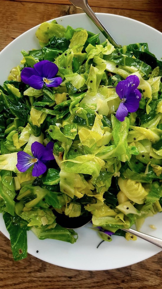 Sweet heads of spring cabbage sautéed in a little oil and butter, with pansies from the garden