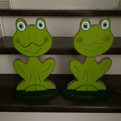 Smiling frogs sitting on lily pads.