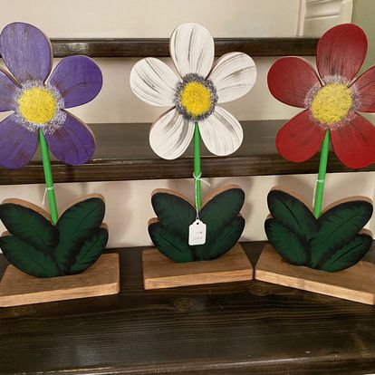 3 flowers with yellow centres and coloured petals.
 