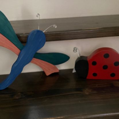 A lady bug and a dragonfly with wired antennae.