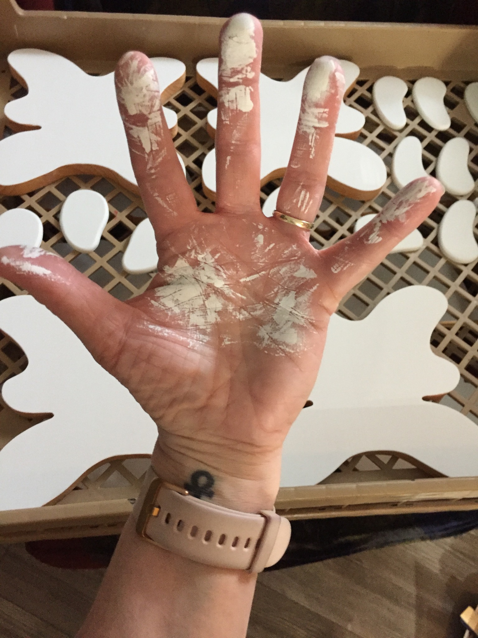 A photo of a hand covered in white paint after a hard day's work.