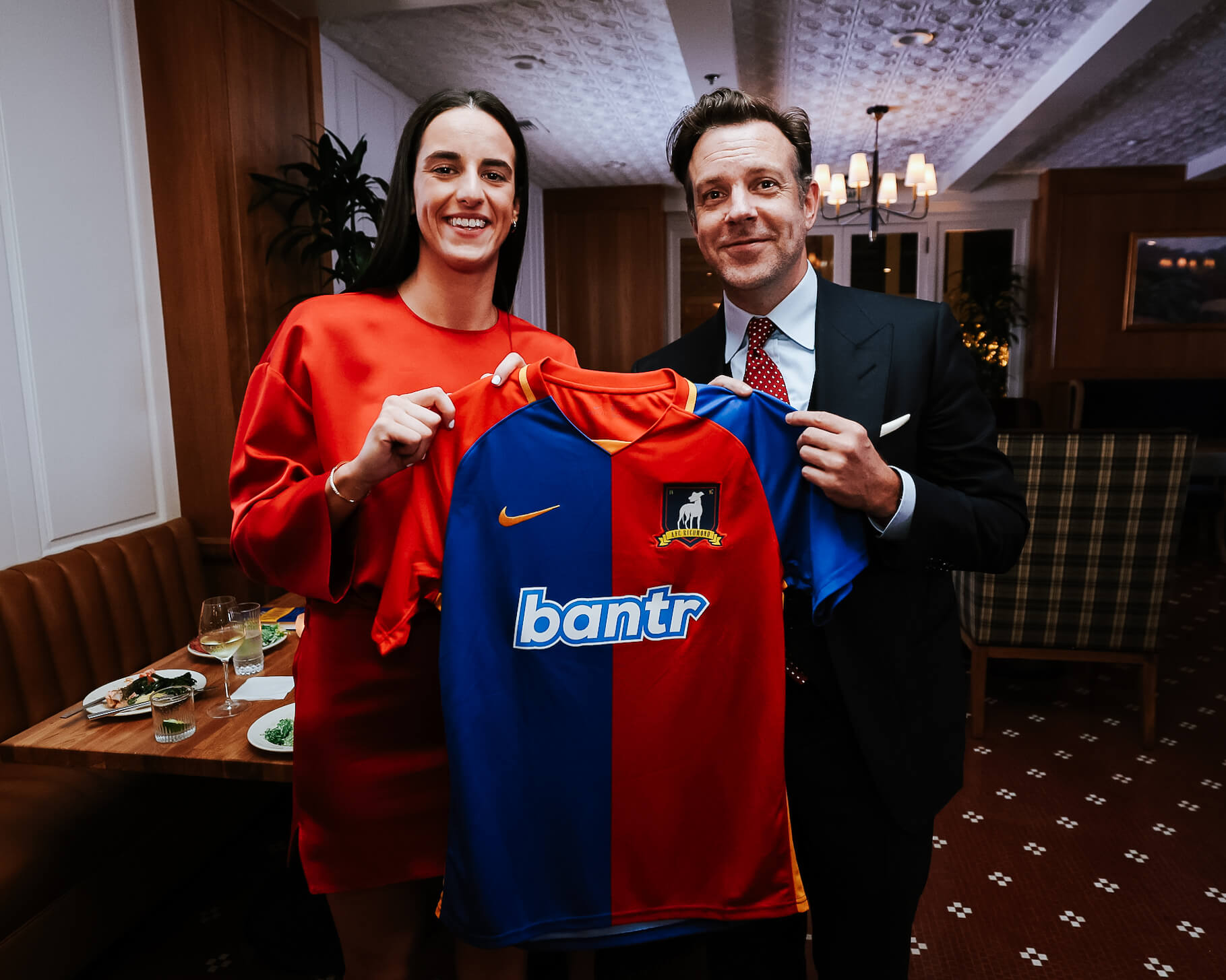 Caitlin Clark and Jason Sudeikis pose holding an AFC Richmond jersey