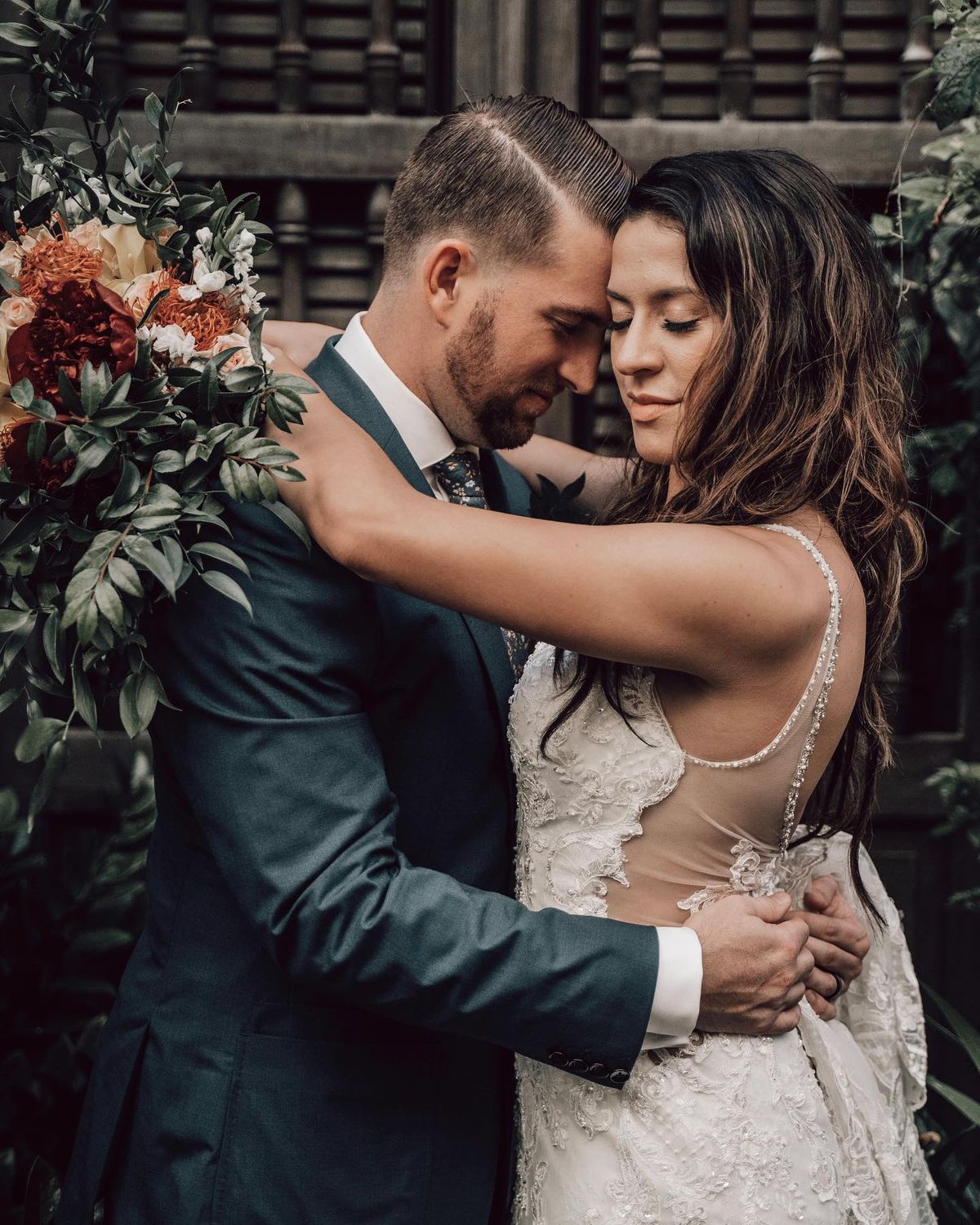 Wedding Photographer for 3 Hours - A close-up of a bride and groom in a tender embrace, surrounded by lush greenery and exquisite floral details