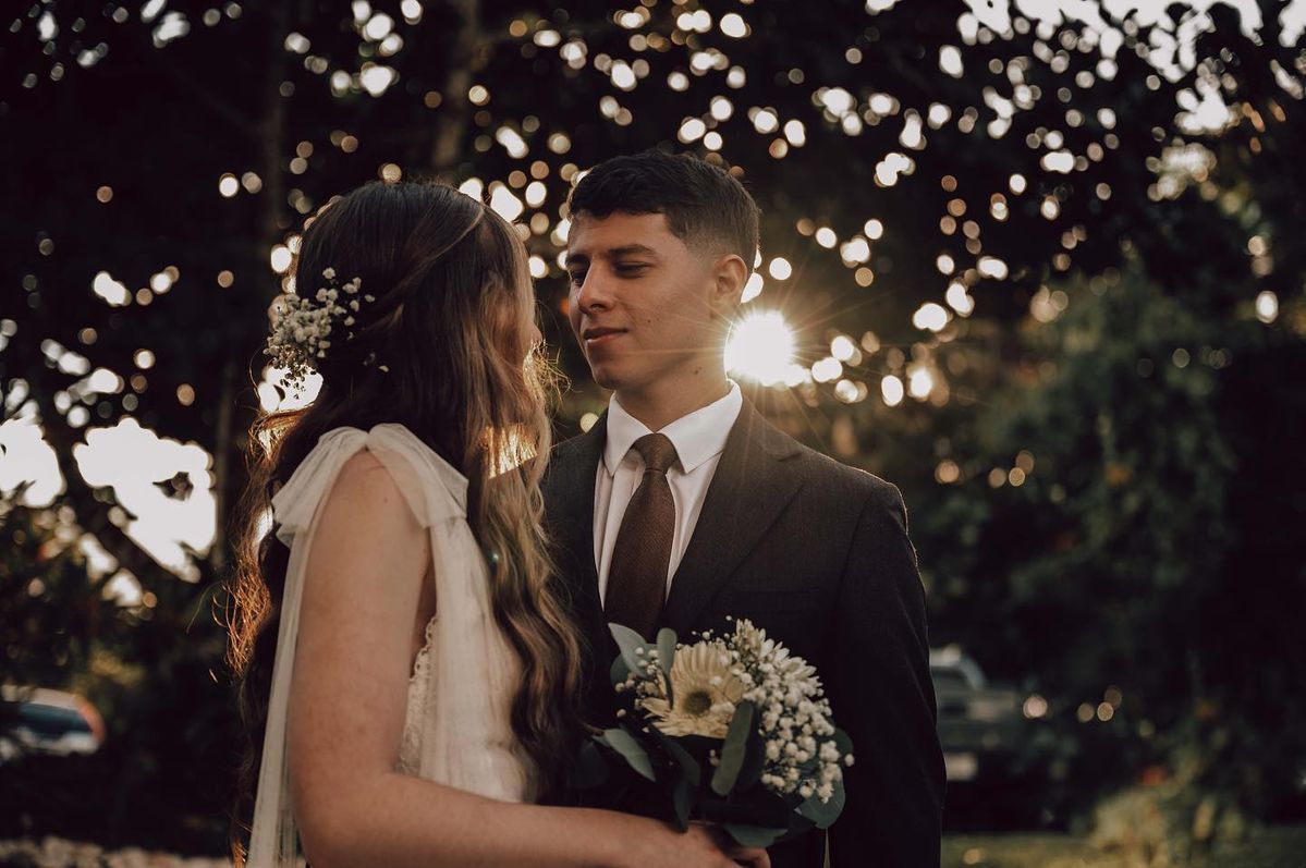 Do I Need a Wedding Planner? - A bride and groom gazing into each other's eyes, backlit by the sun with sparkling bokeh, the bride holding a bouquet