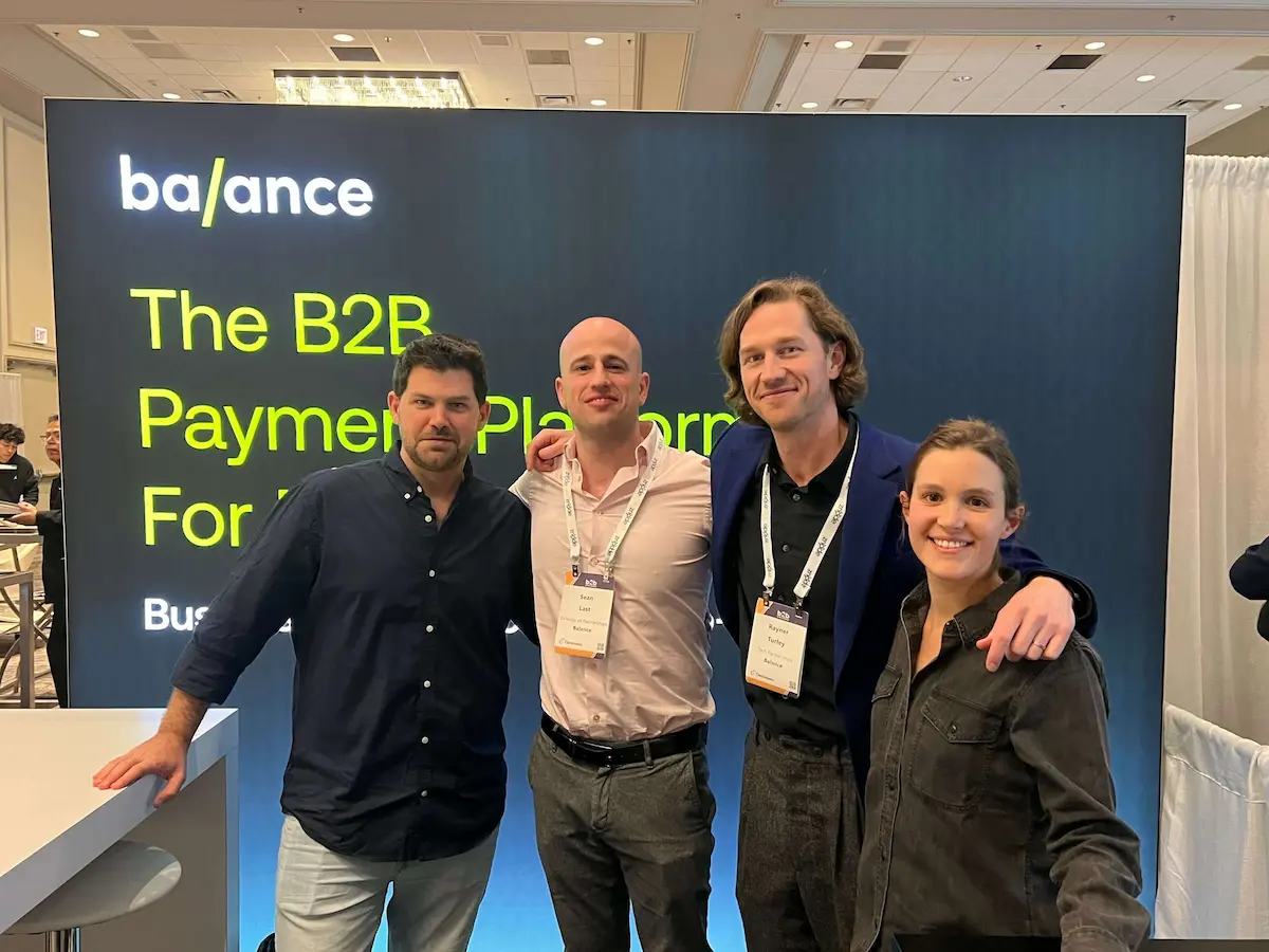 Four members of the Balance team posing in front of the Balance booth at B2B Online 2023.B