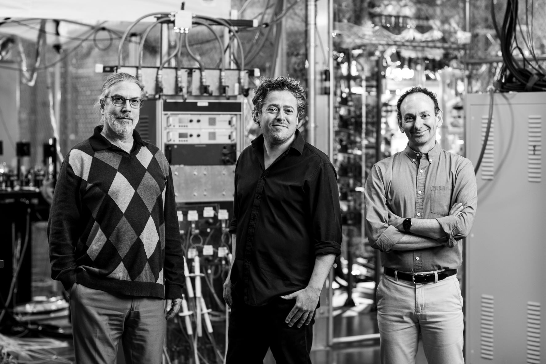Photo of three men standing in front of a lot of hardware