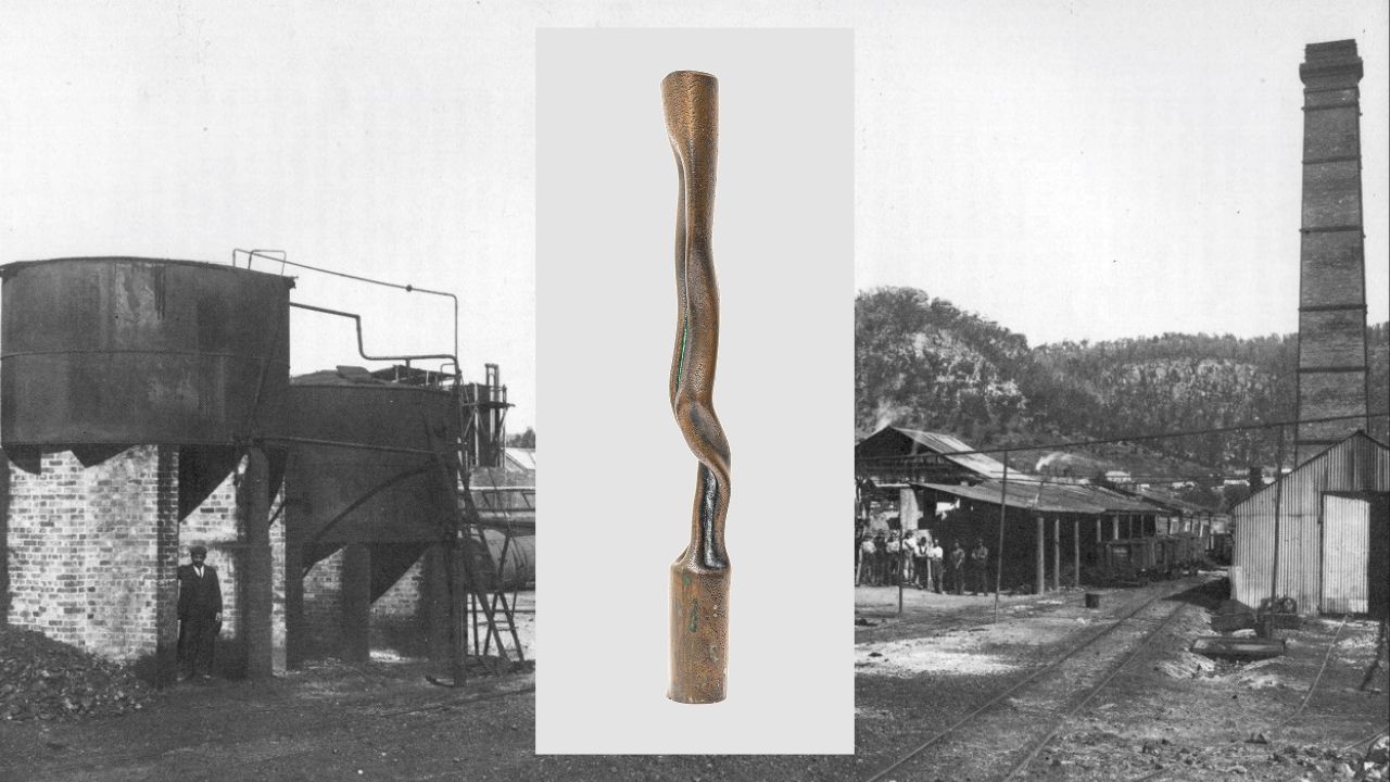 A compressed and distorted piece of metal is at the foreground of the industrial landscape of a kerosene refinery.