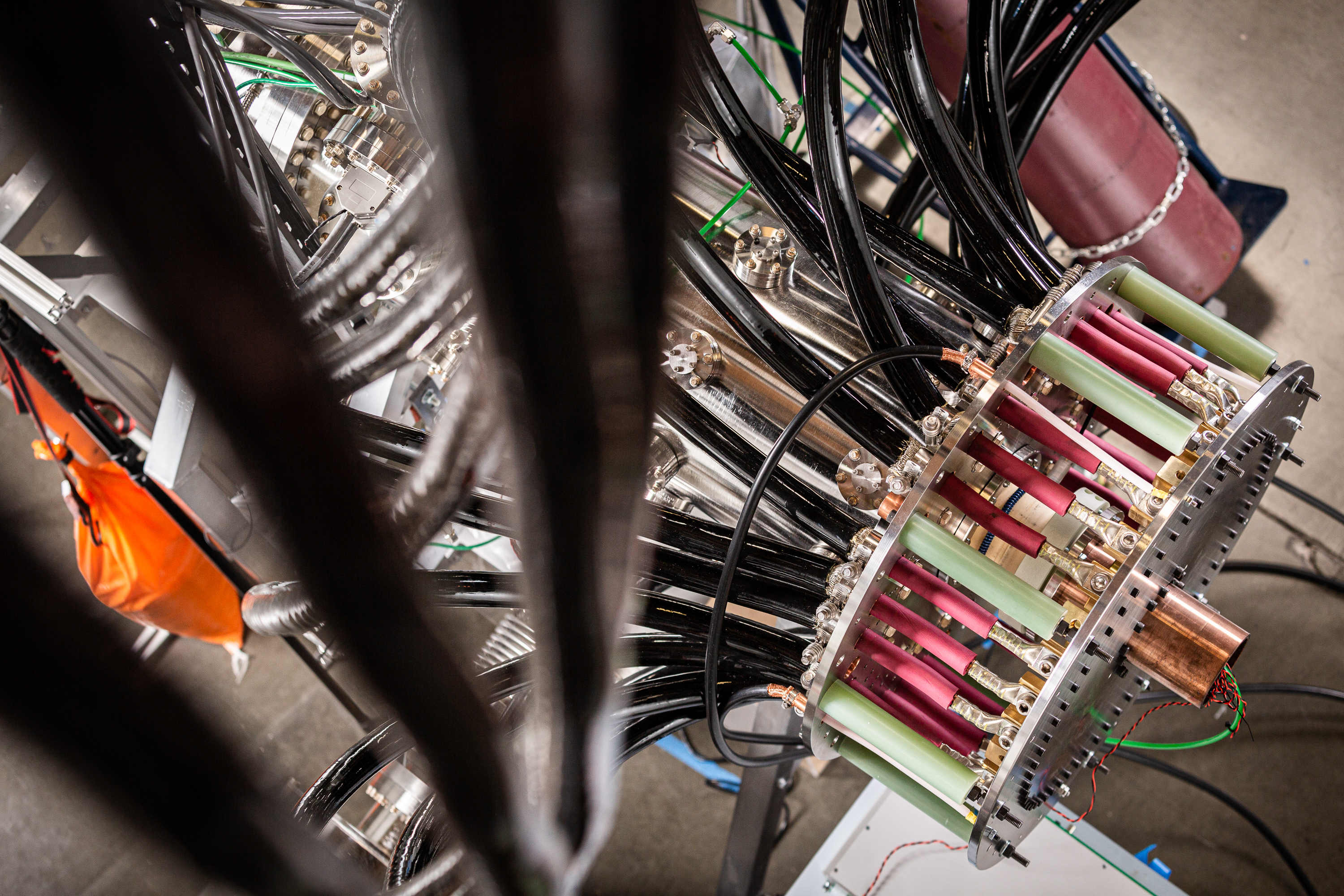 A bevy of thick, insulated electrical wires converge into the crown-shaped steel head of a Zap Energy fusion device.