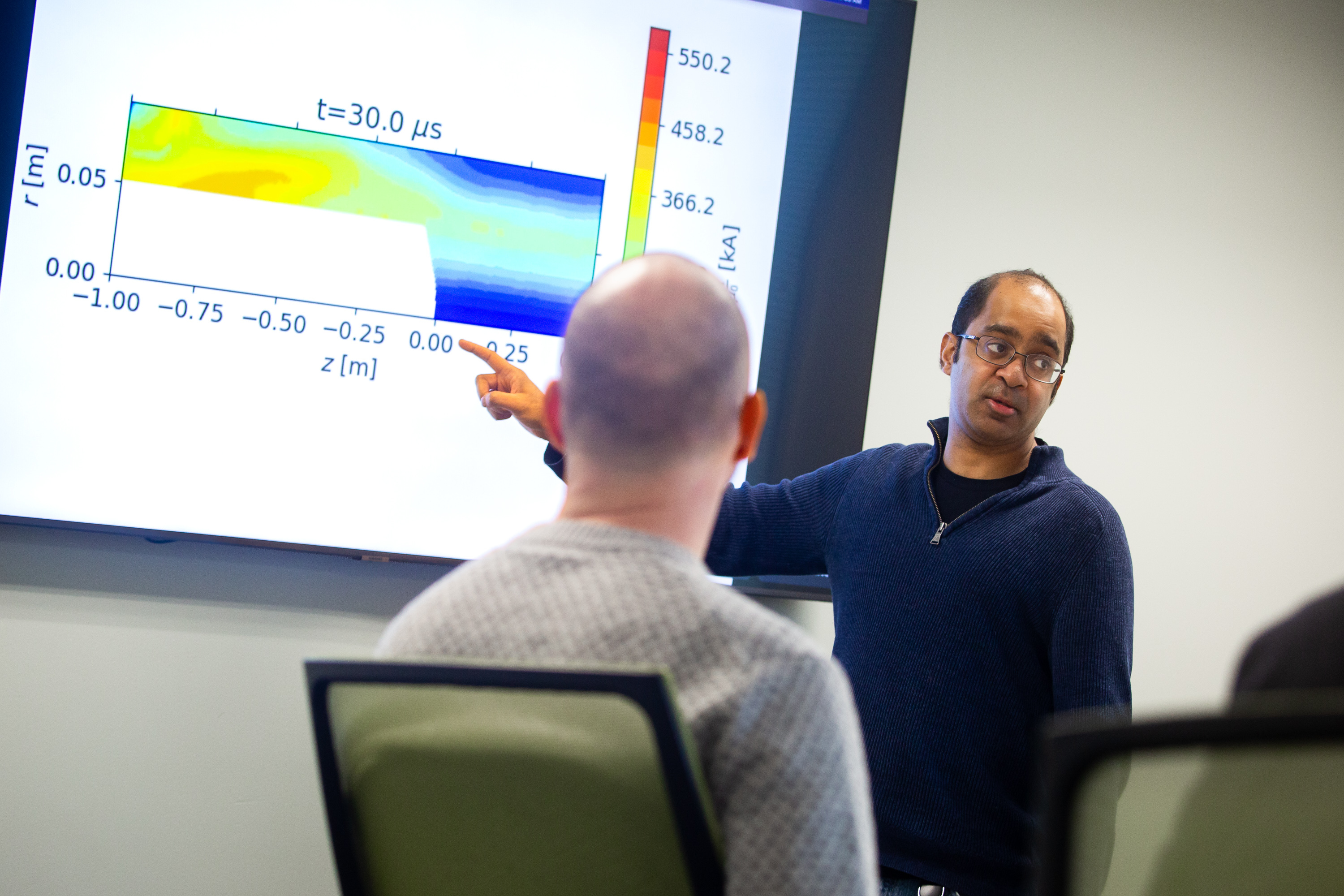 With a colorful graphic, a scientist explains how a sheared-flow-stabilized Z-pinch fusion plasma is modeled.