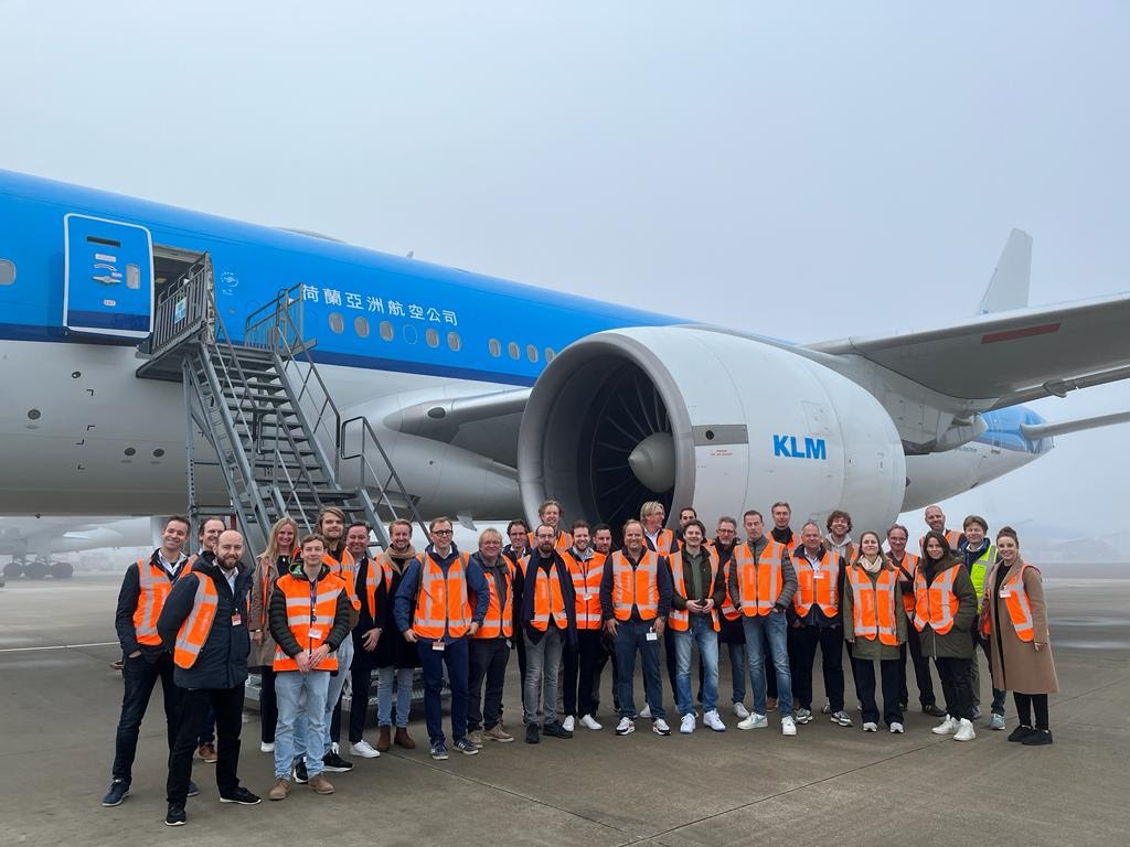 Deelnemers aan de AI Experience Schiphol 2023 voor een KLM vliegtuig