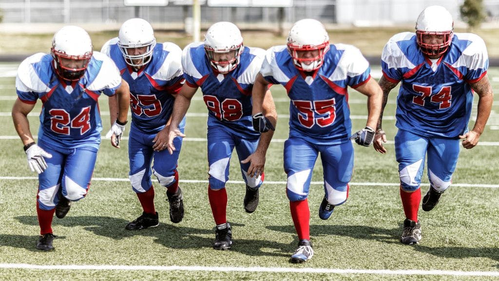 Football team running down the field showing their football socks