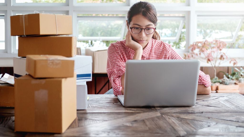 Woman sitting in her office in a nonprofit fulfilling orders from her online merchandise store