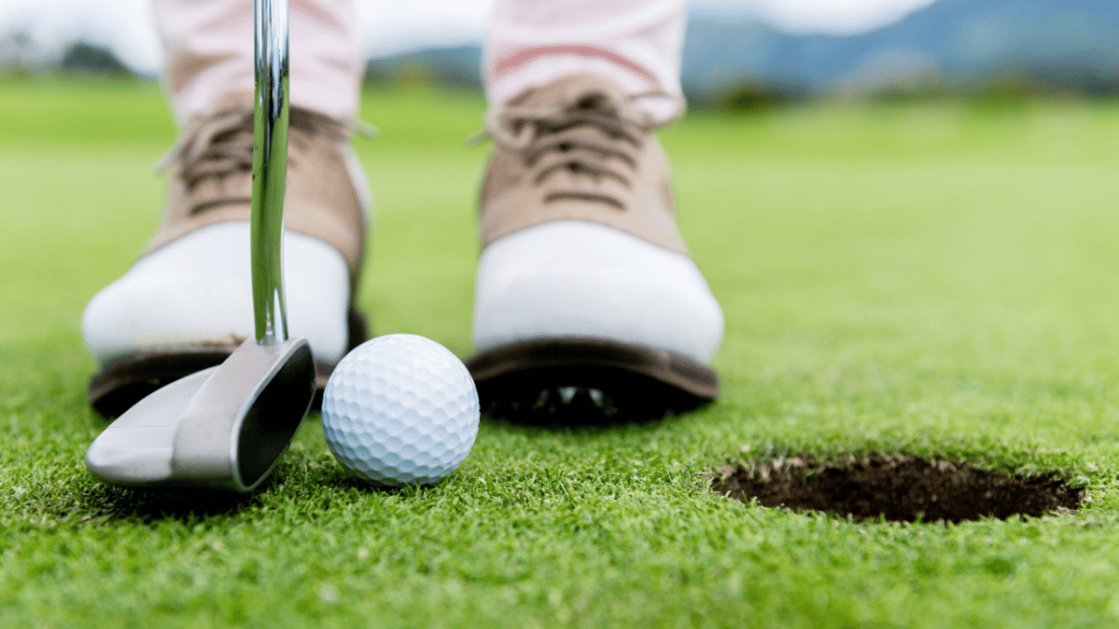 man standing on golf putting green wearing swag bag items