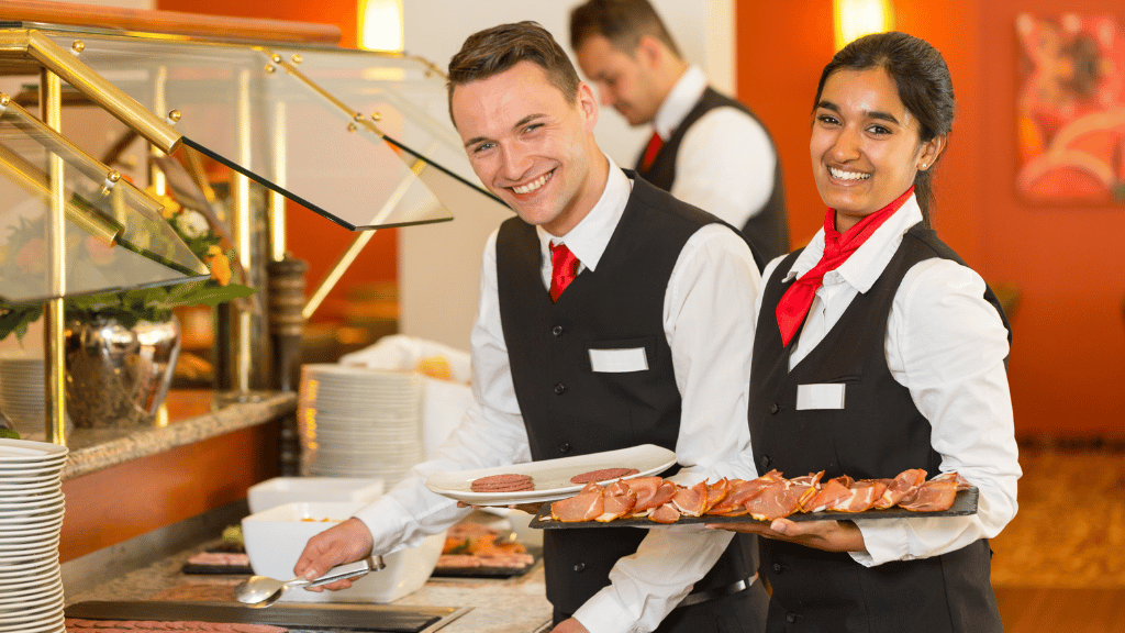 group of waiters and waitresses smiling while serving food for food service week