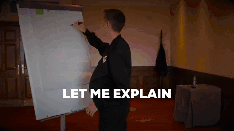  A person in a black suit stands next to a flip chart, writing on it with a marker. The text "LET ME EXPLAIN" appears in bold white letters at the bottom of the image. The scene takes place in a room with wooden doors and a red carpet, suggesting a formal setting or a presentation.