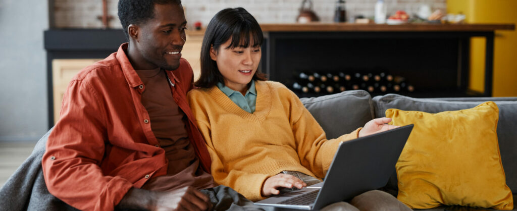 Young Couple Using Laptop On Couch