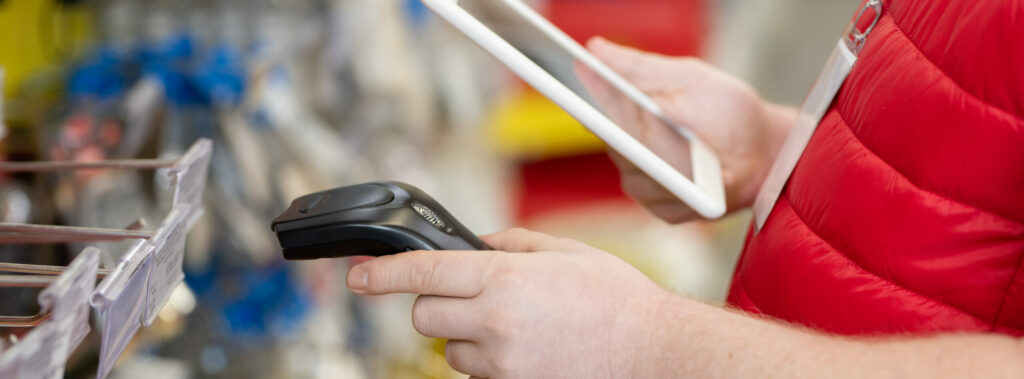 Sales Manager Scanning Price Tags In Hardware Store