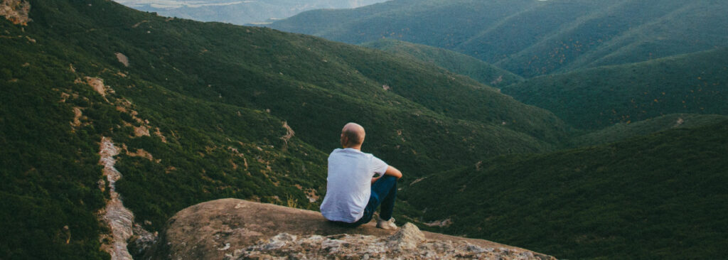 I Can't Pay My Eidl Loan: man sitting on the top of a mountain
