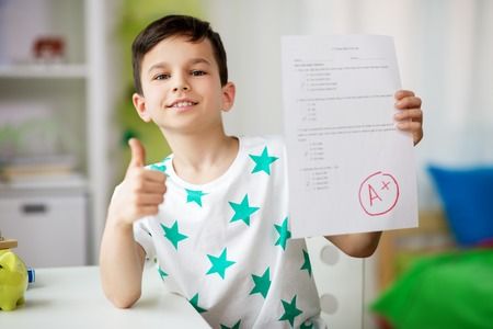 Smiling student holding an answer sheet with a good grade