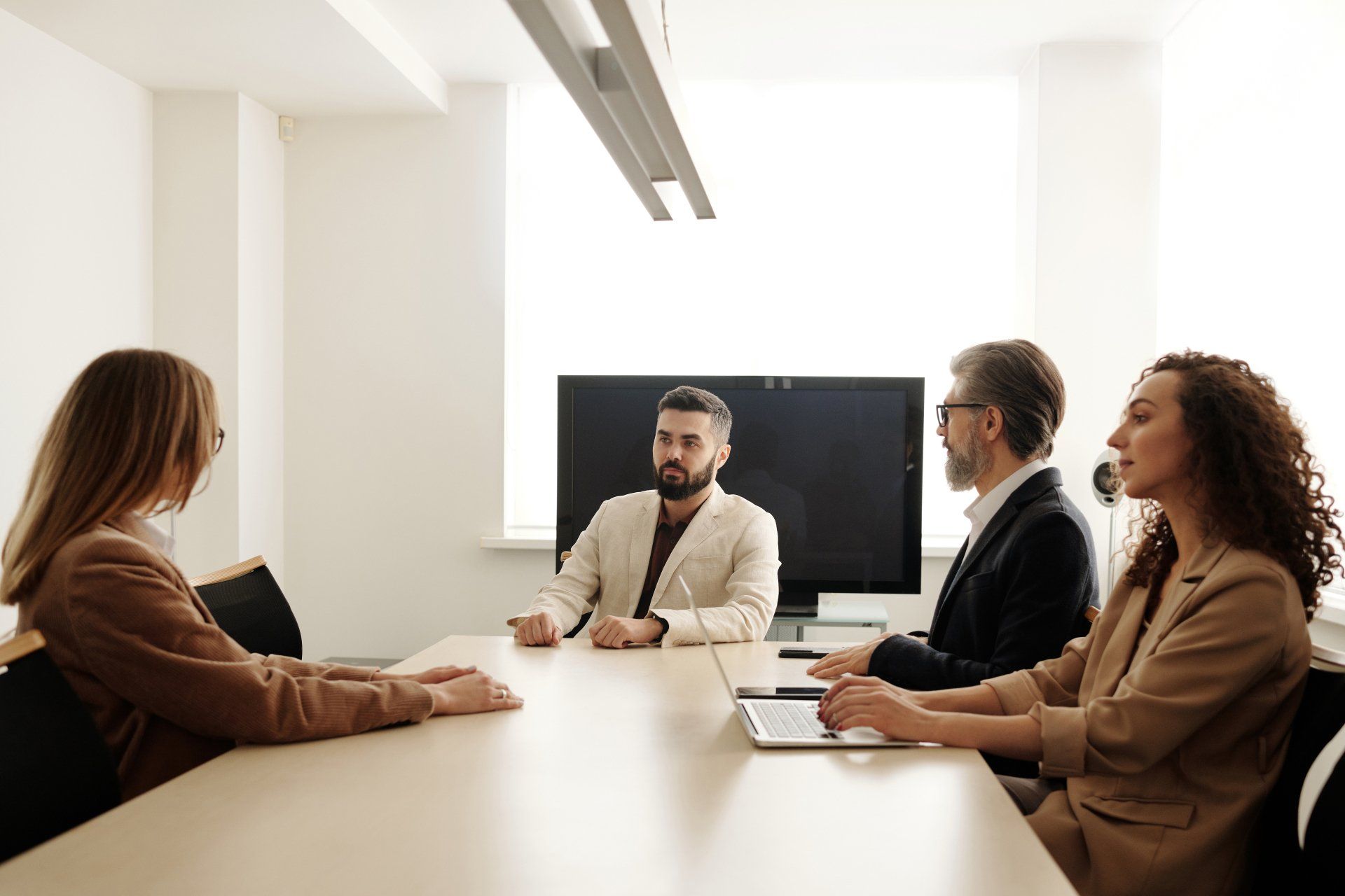 Sales leaders conducting a team meeting in a modern office, discussing clear goals, collaboration, and continuous improvement strategies.