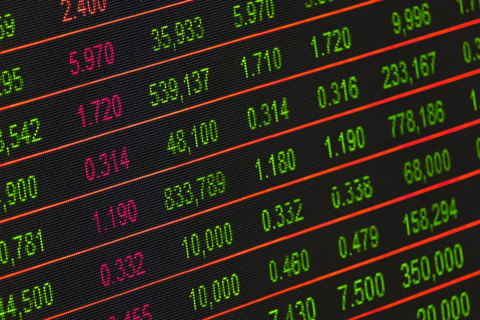 Digital stock market display showing financial data and stock prices in green and red, illustrating financial trends related to fractional management and corporate agility.